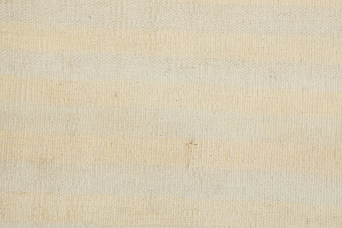Close-up of the low wool pile, showing the hand-knotted texture and the distinct striped design.