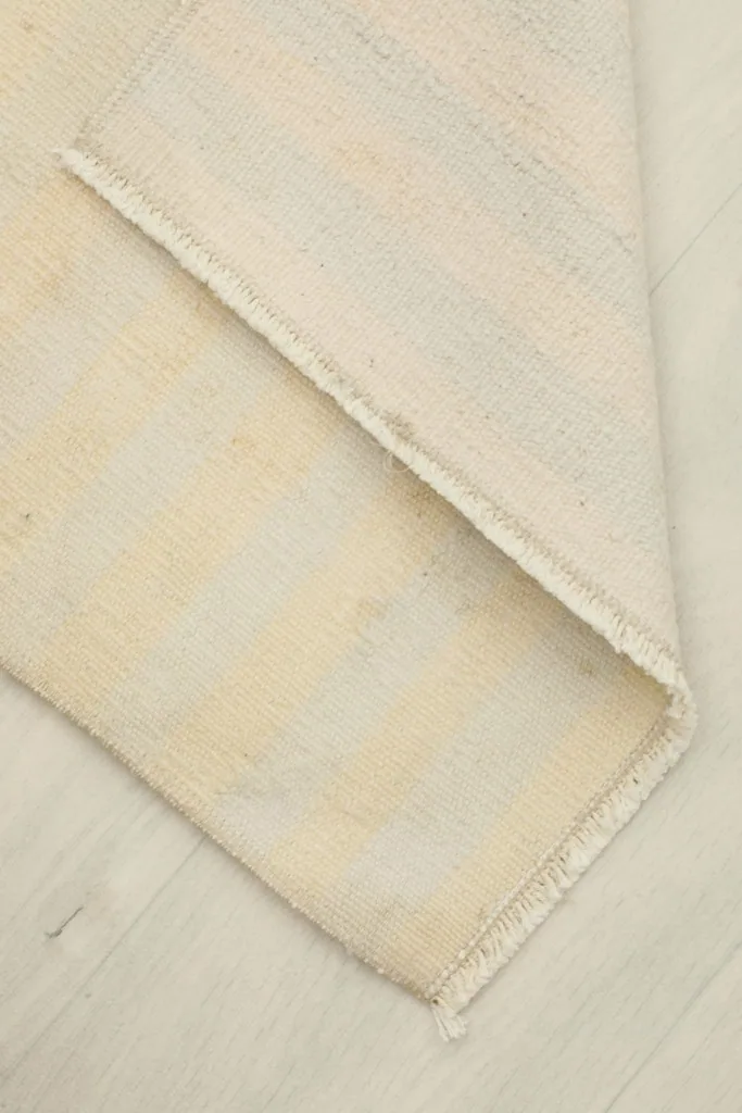 View of the rug's back, revealing the cotton foundation and the neat hand-knotted construction.