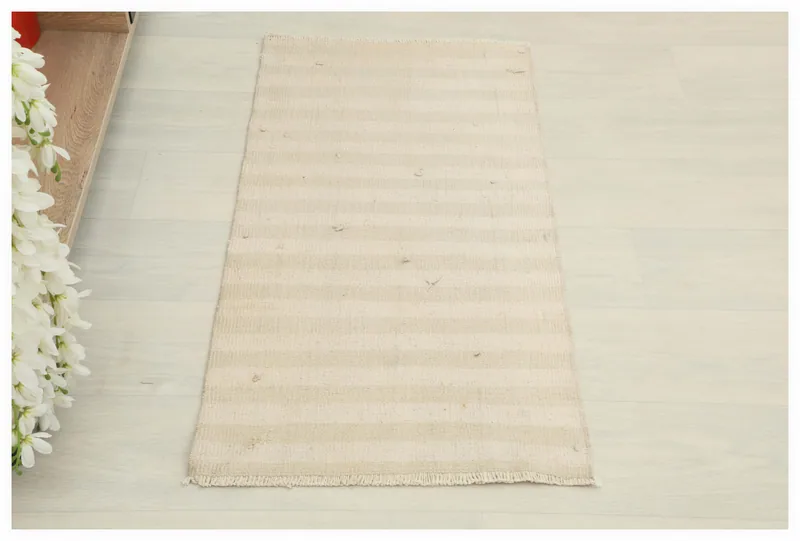 Full top view of the beige and ivory striped vintage Anatolian doormat on a white background.