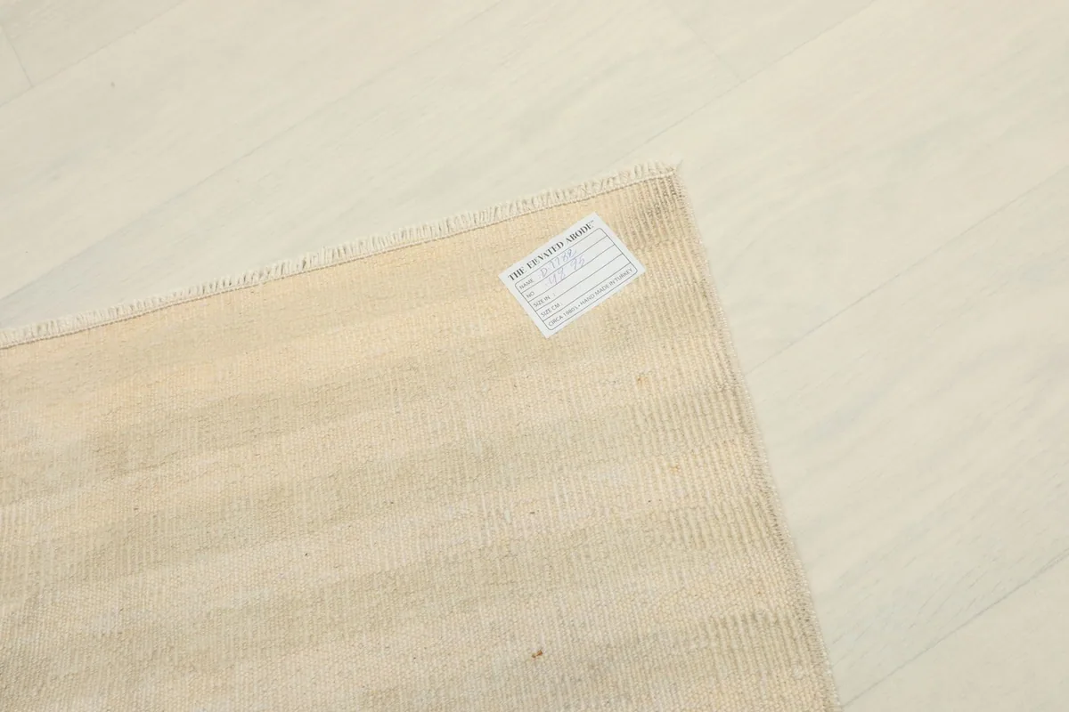 Close-up of the care label attached to the back of the vintage Anatolian doormat.