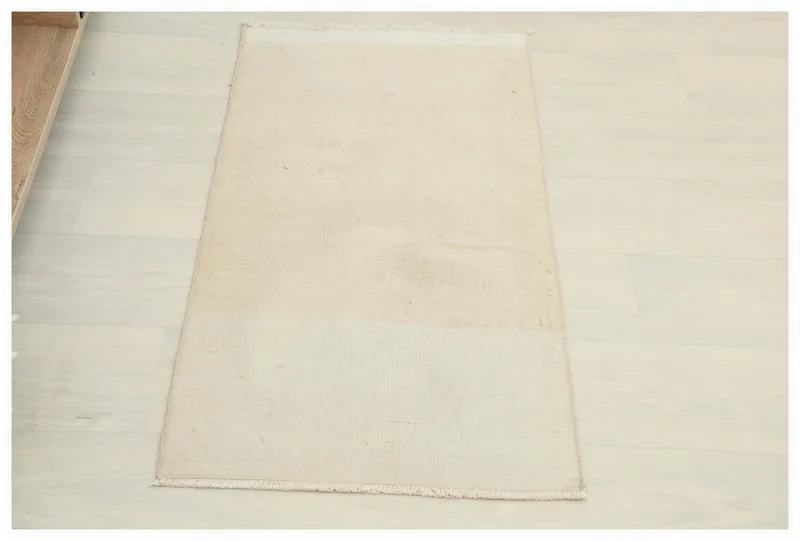 Full top view of the 1'7" x 3'1" beige vintage Anatolian rug on a white background