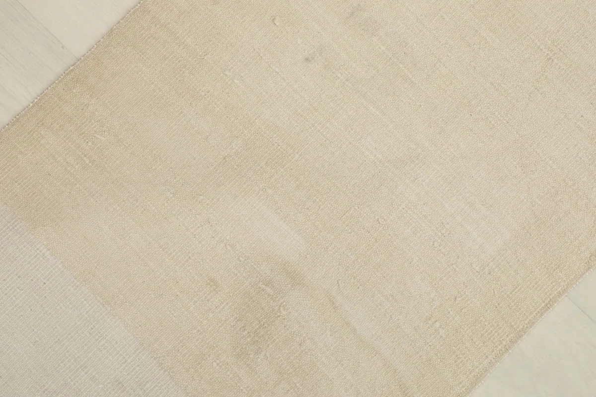 Overhead view showing the subtle color shifts and texture across the beige vintage rug