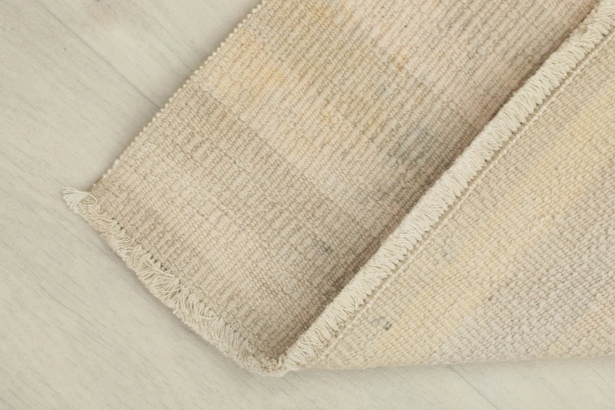 Close-up of a corner, highlighting the texture, fringe, and a slight fold of the rug.