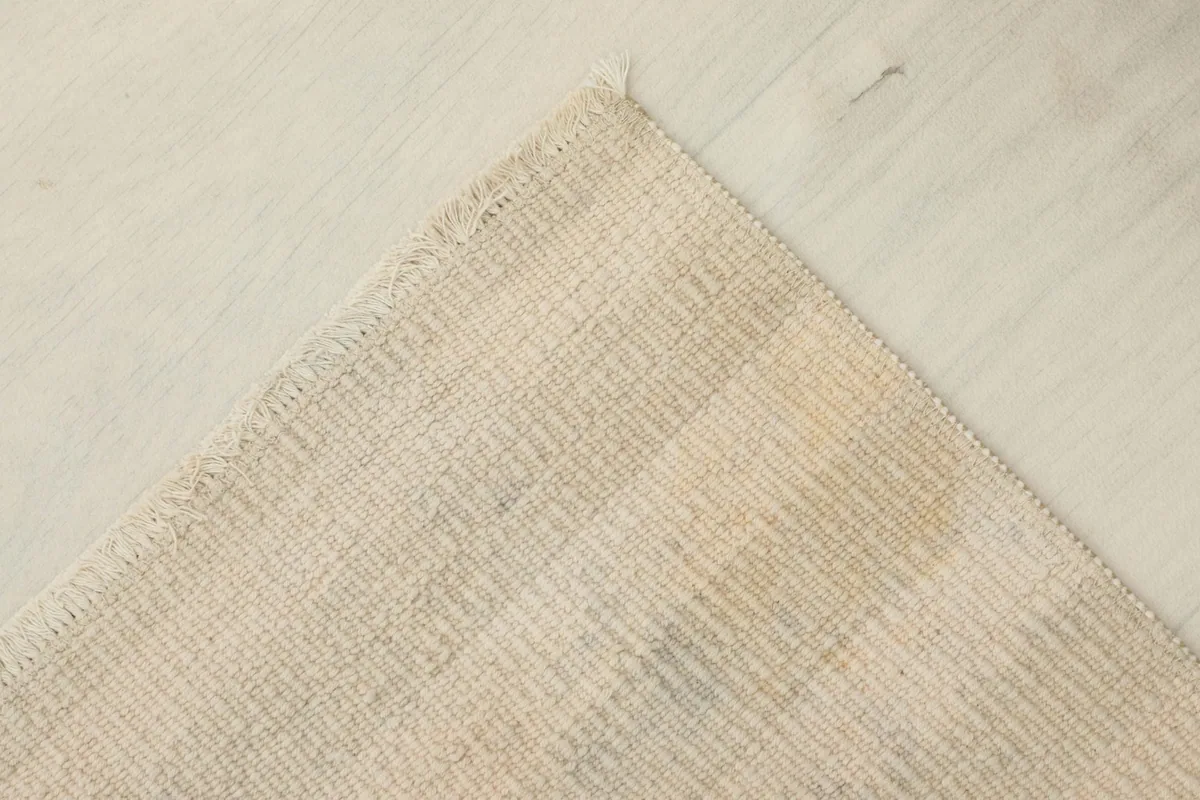 Corner view revealing the cotton foundation and the reverse side of the hand-knotted vintage rug.