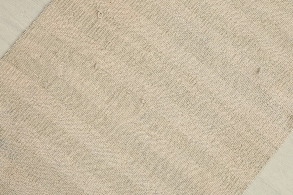 Overhead view highlighting the natural variations and texture within the ivory and cream wool pile.