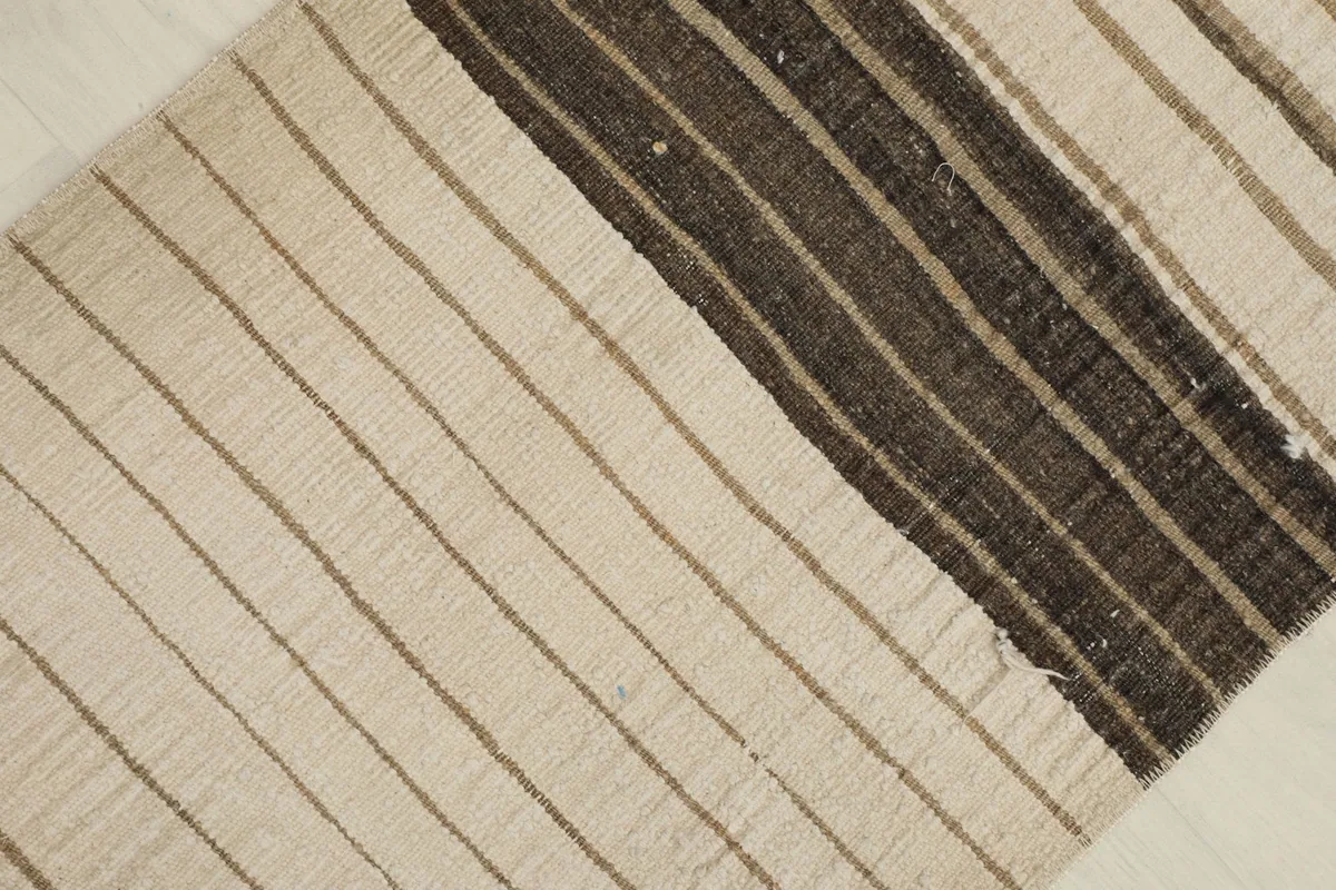 Detailed view of the darker brown and charcoal striped section of the vintage Anatolian rug.