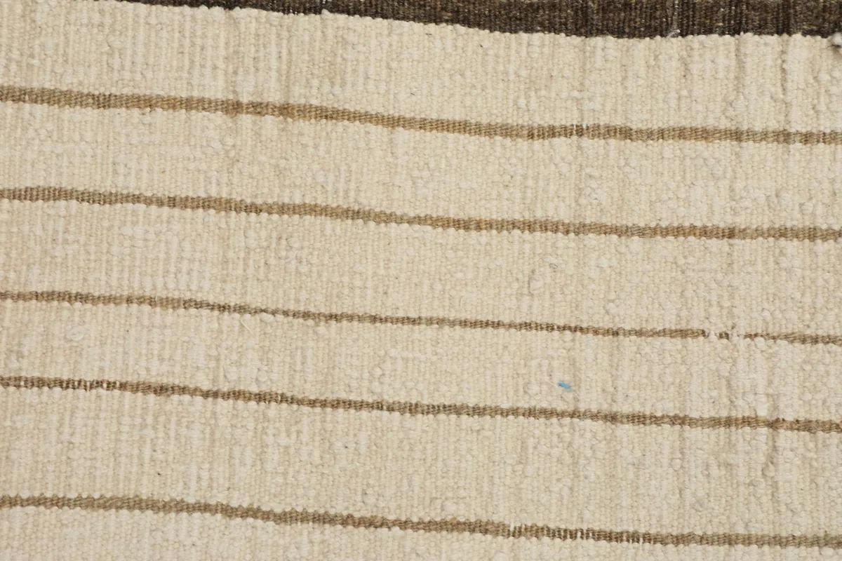 Close-up of the low wool pile texture and the subtle beige and tan stripes.