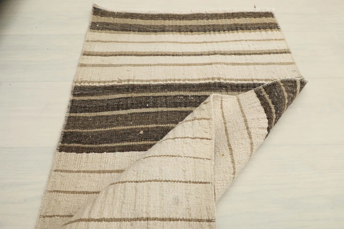 The doormat folded over, showing both the front pile and the reverse side with its construction.