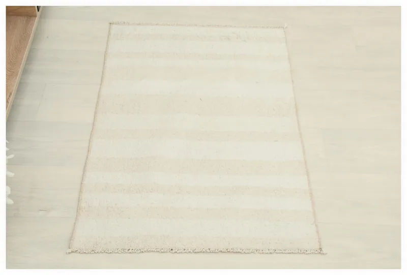 Full top view of the 1'9" x 2'11" cream and beige striped Anatolian rug on a light floor.