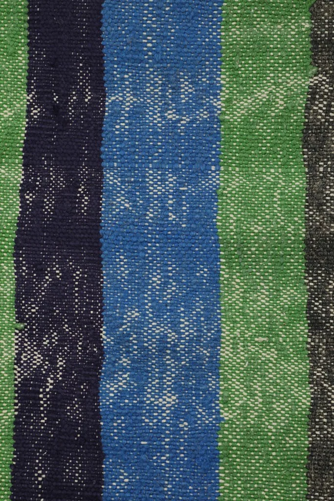 Tight close-up of the blue, navy, green, and gray stripes, revealing the texture and patina of the wool.