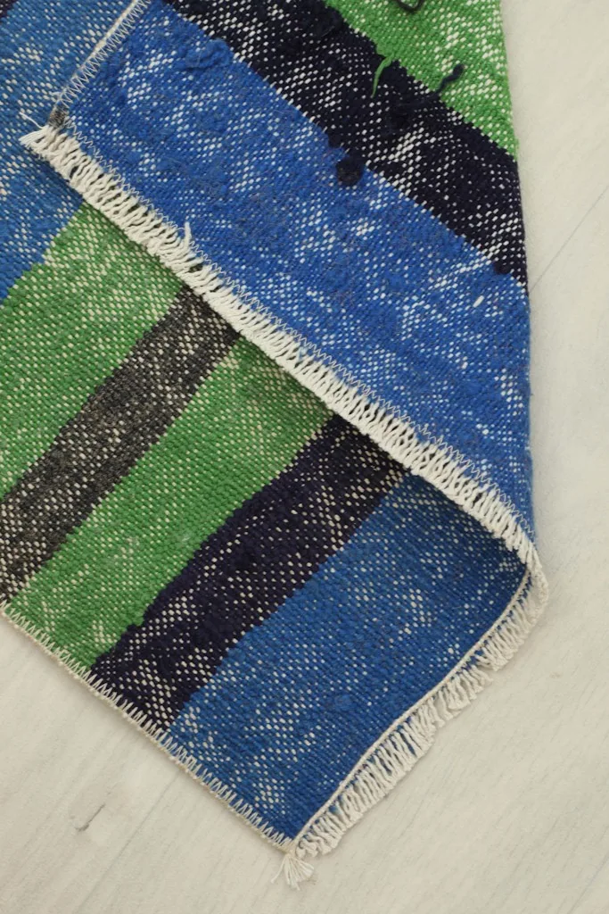 The rug partially folded, showing its flexibility and the reverse side along the fold.