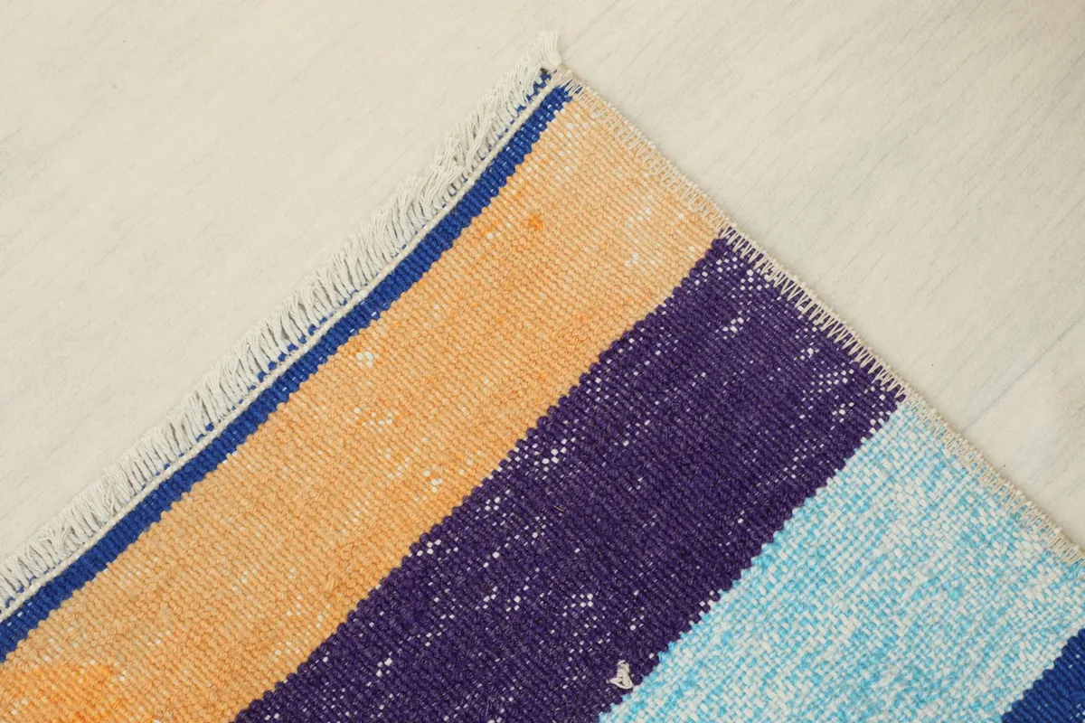 Angled detail of a corner, highlighting the fringe and the transition between colors.