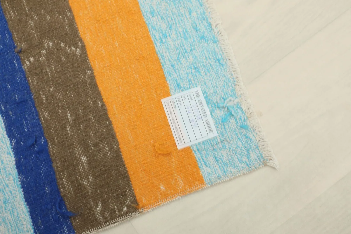 Detail of the rug's back with a label, showing the hand-knotted cotton foundation.