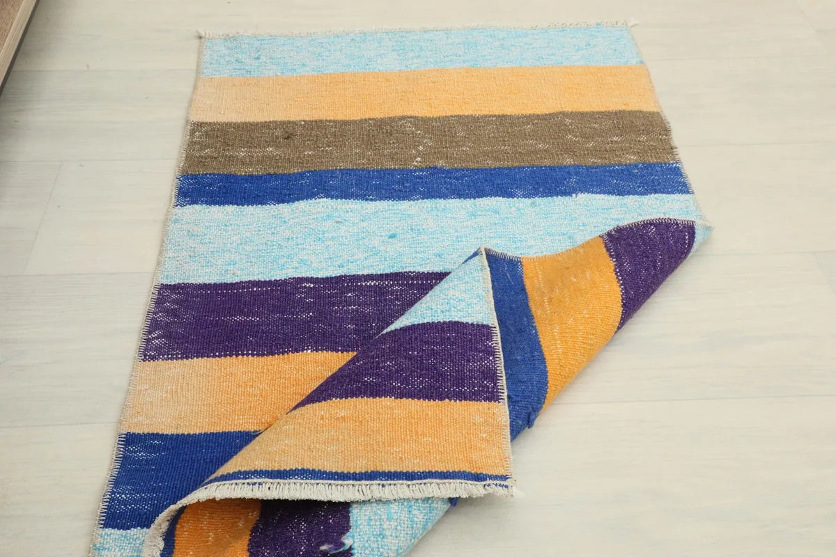 The rug partially folded on a light floor, demonstrating its drape and size.