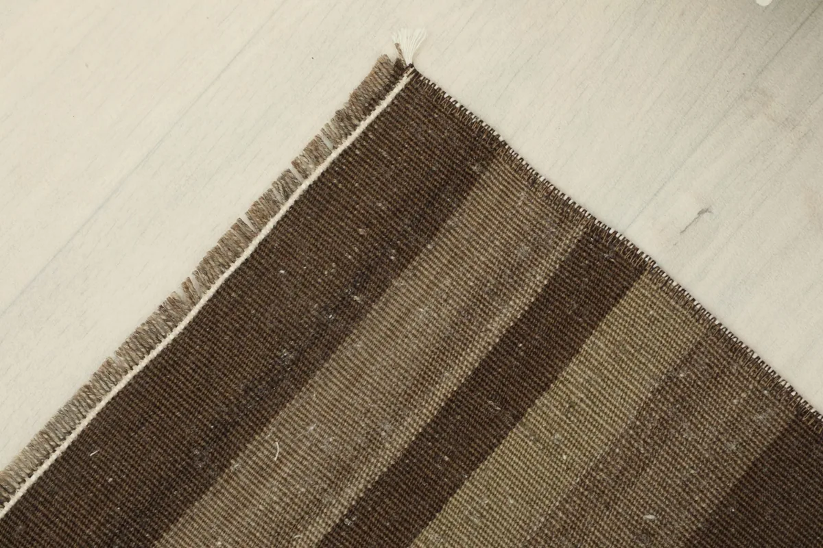 Corner view of the hand-knotted rug, revealing the subtle color shifts within the stripes.