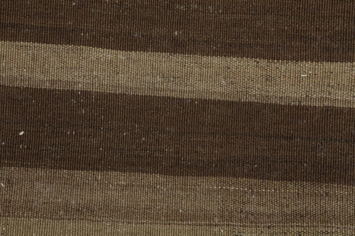 Detailed view highlighting the variations in the brown and tan wool yarns in the striped design.