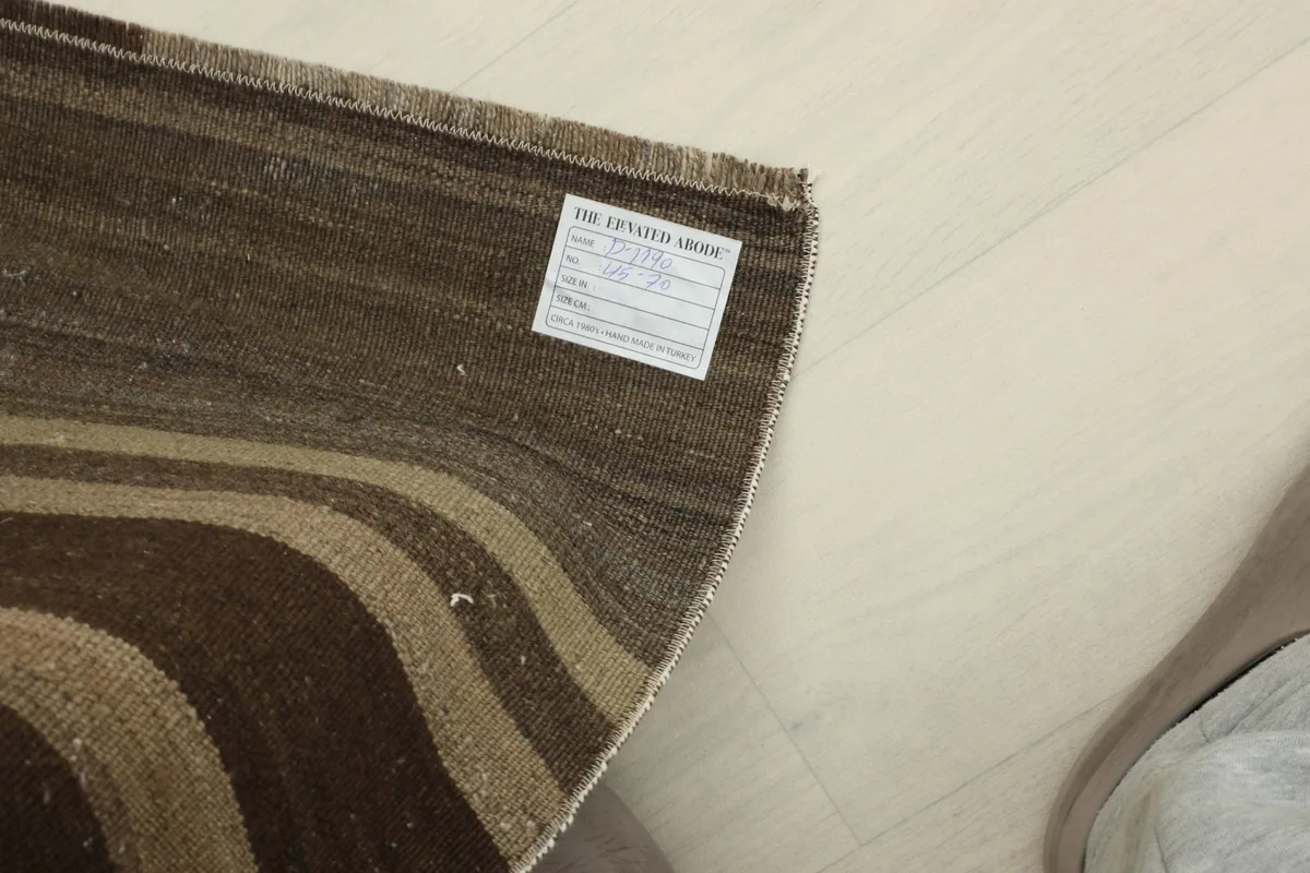 Underside view of the rug, showing the hand-knotted construction and a product label.