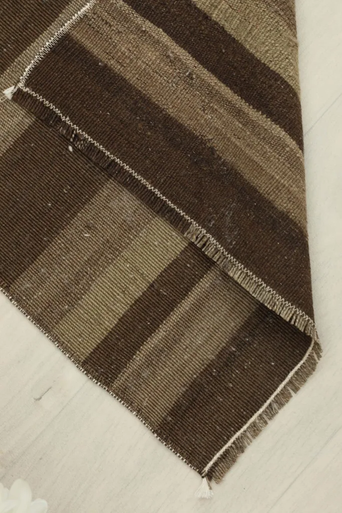 Rug partially folded, displaying the thickness of the wool pile and cotton foundation.