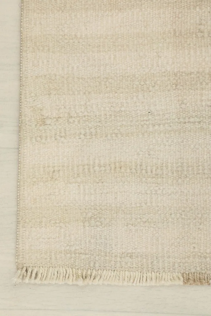Detail of the corner, showing the finished edge and the short, natural fringe of the rug.