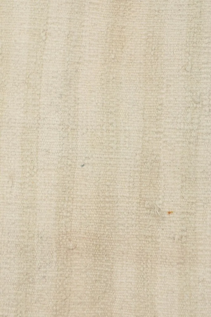 Tight close-up of the low wool pile, revealing the natural fiber texture and slight variations in color.