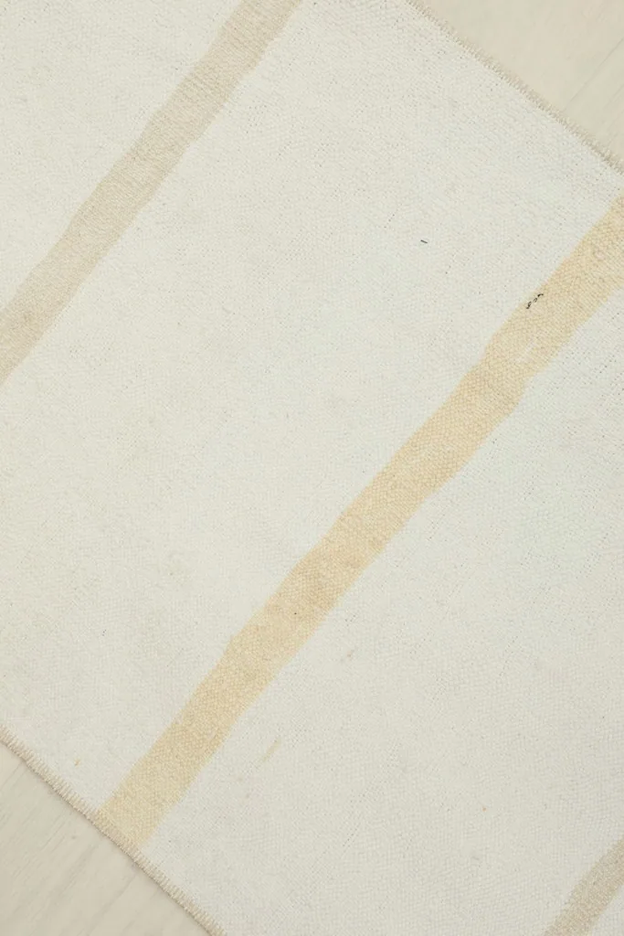 Close-up of a tan stripe against the cream field, showcasing the wool texture and weave.
