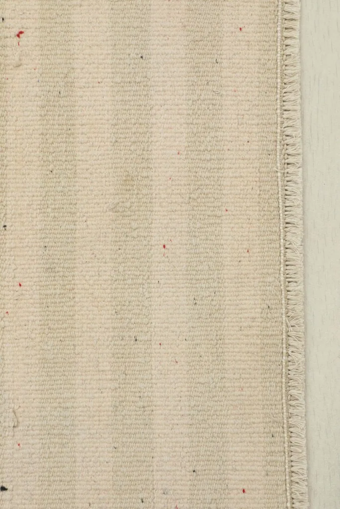 Close-up of the beige stripes and fringed edge, highlighting the wool texture and hand-knotted detail.