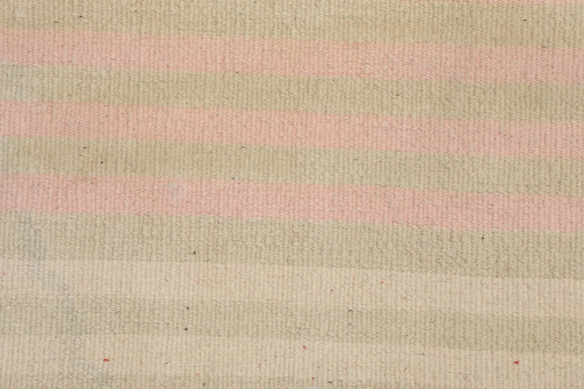 Detailed view of the low wool pile, showing the alternating beige and pink striped pattern.