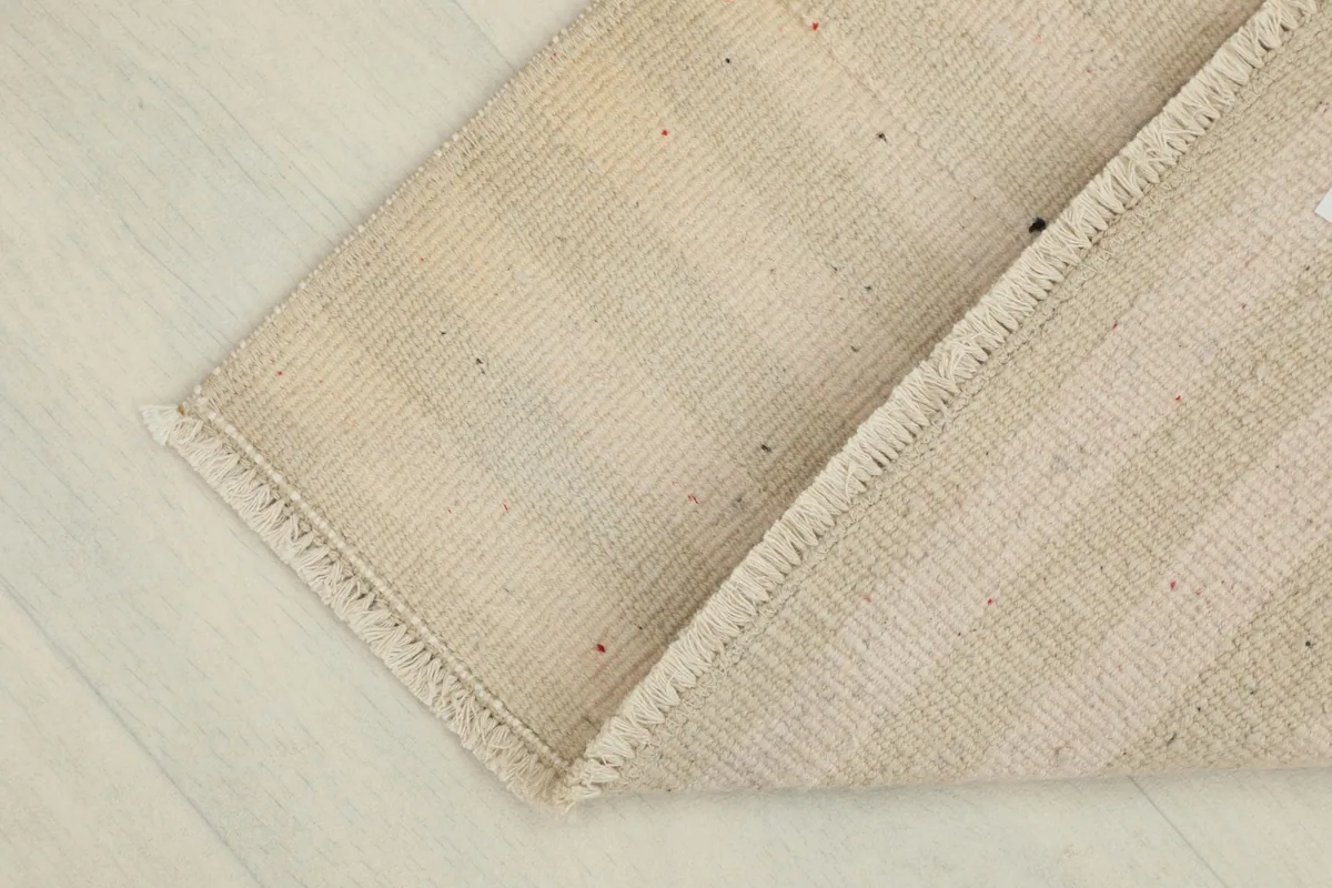 View of the rug folded to show its flexibility and the texture of both the front and back.