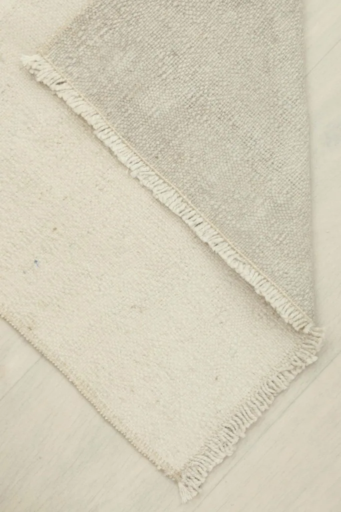 The rug folded to reveal the reverse side, showing its thickness and construction