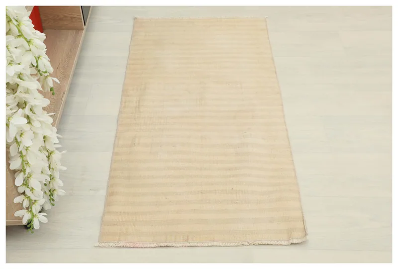 Full top view of the 1'9" x 3'7" beige striped vintage Anatolian wool rug on a white background.