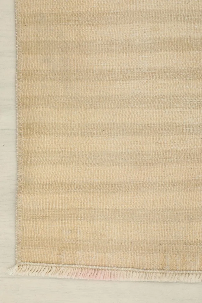 Close-up of a corner, showing the finished edge and a hint of the cotton foundation underneath the fringe.