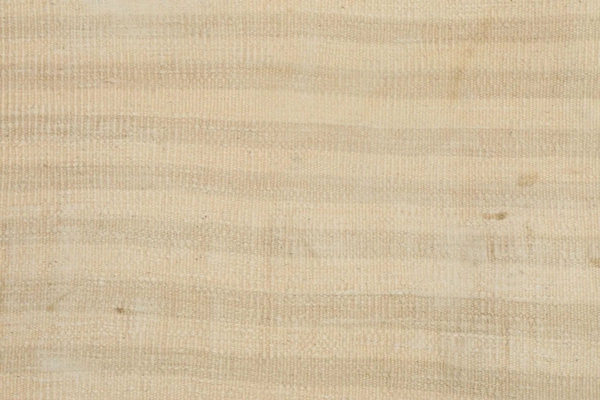 Detailed view of the rug's hand-knotted wool pile, showcasing the horizontal beige and tan stripes.