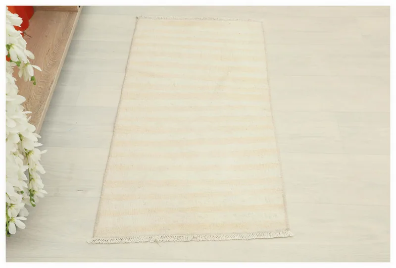 Full overhead view of a cream and beige striped vintage Anatolian rug