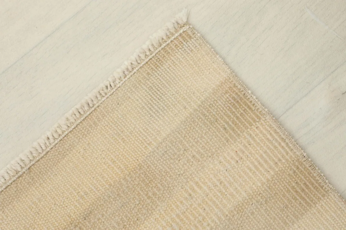 Overhead angled shot of the rug's corner, emphasizing the subtle color shifts in the stripes.