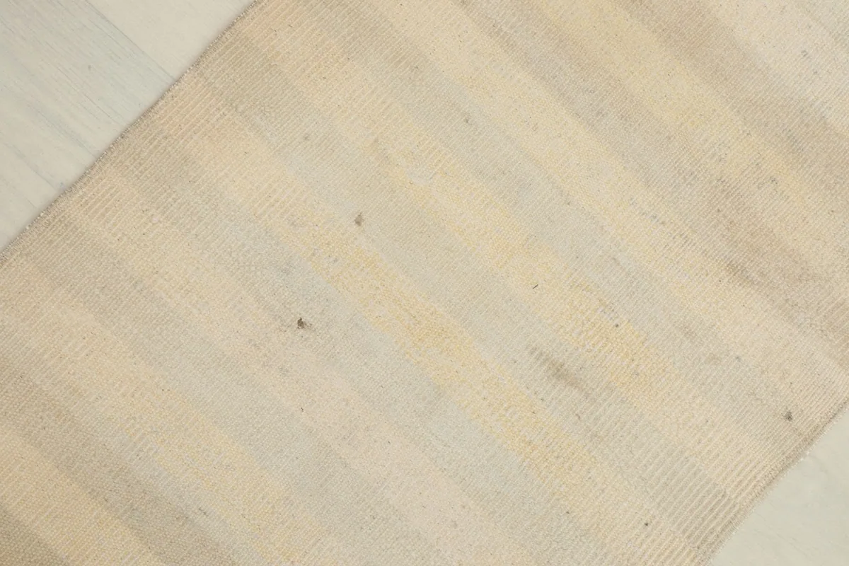 Surface detail showing the low pile and slight variations in the beige and cream wool stripes.