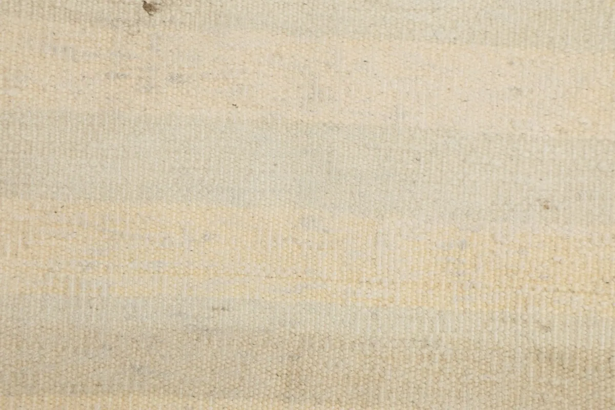 Extreme close-up of the rug's low wool pile, revealing the texture of the hand-knotted construction.