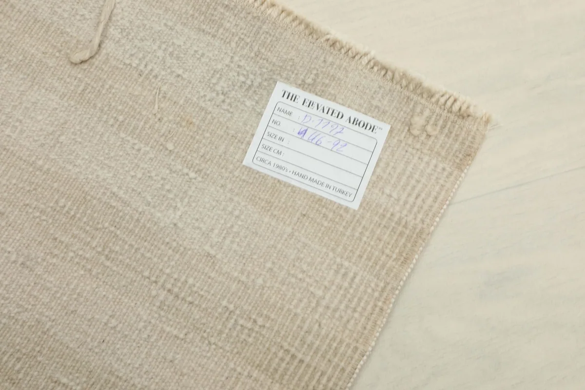 Close-up of the rug's back, showing the care label and the tightly woven cotton foundation.