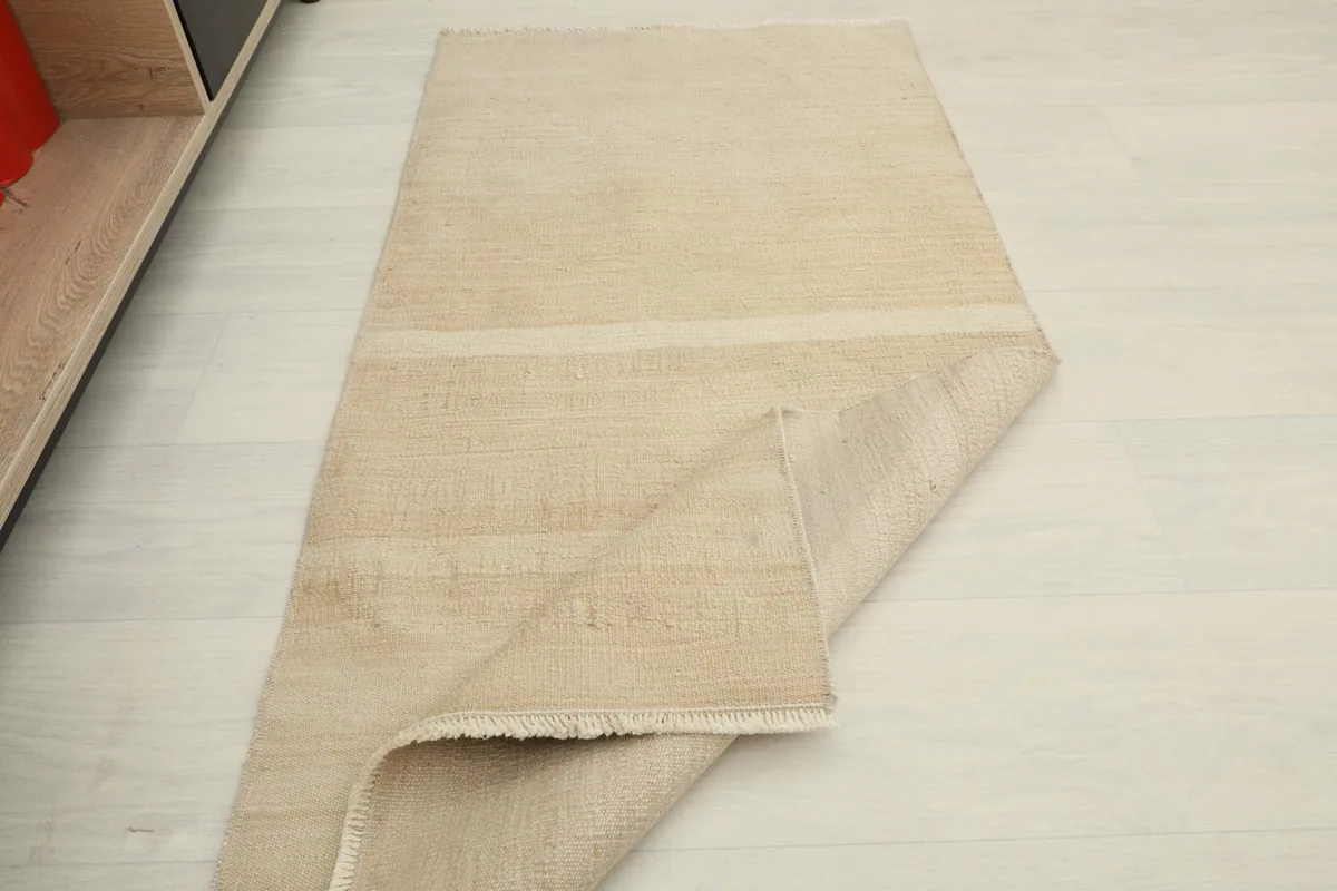 Rug partially folded, illustrating its pliable nature and the clean back of the weave.