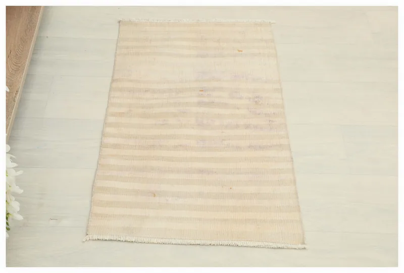 Full top view of the 1'6" x 2'7" cream striped vintage Anatolian doormat on a white background.