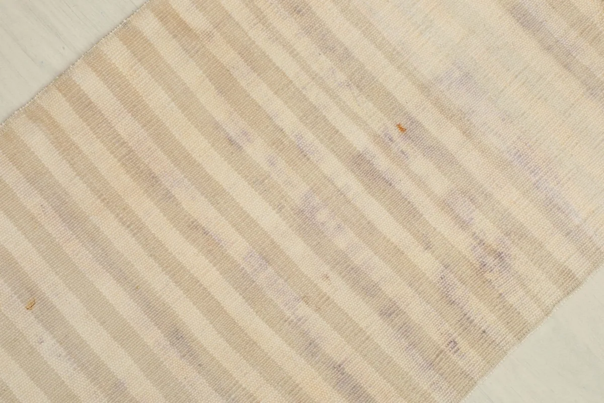 Close-up of the striped pattern across the rug's surface, with hints of purple and rose.