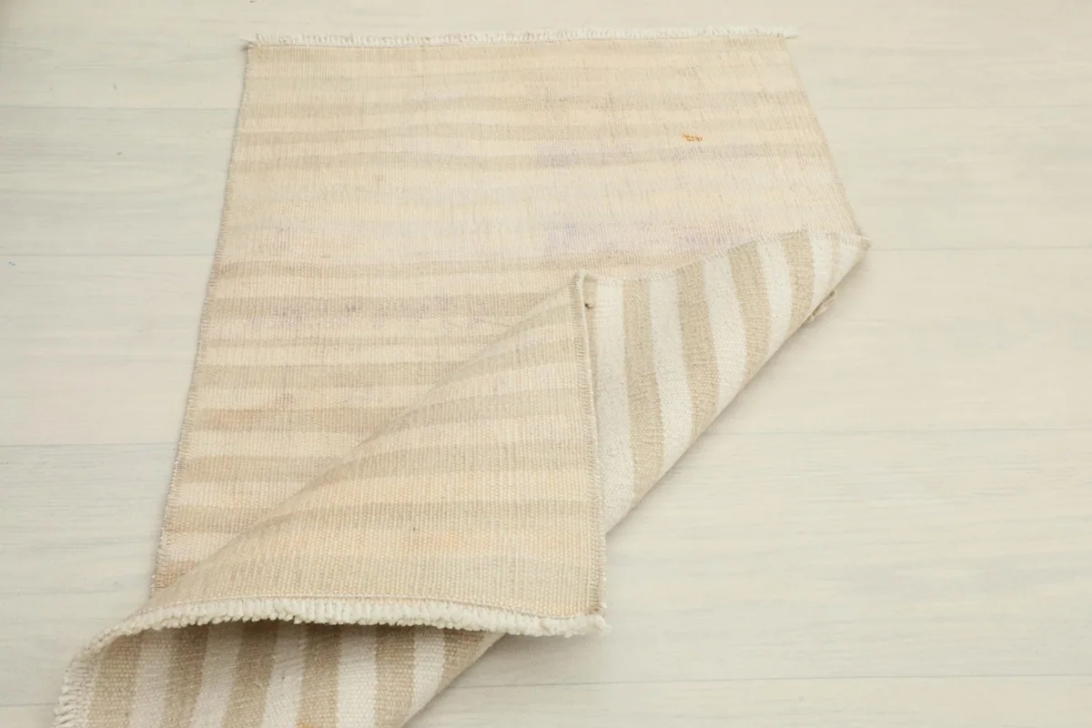 Another folded view of the rug, displaying the back of the rug with its striped pattern.