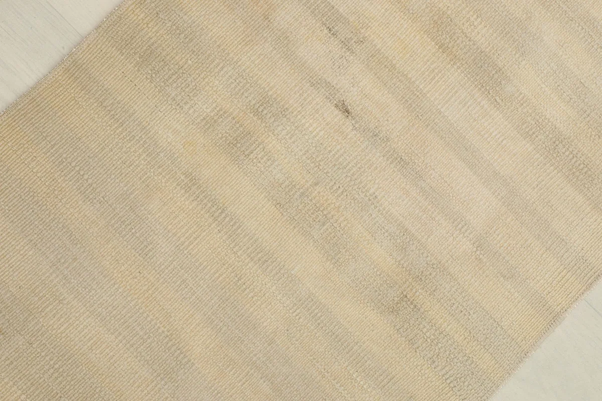 Diagonal close-up of the rug's low pile and natural color variations.