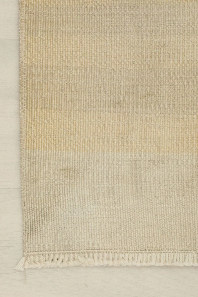 Close-up of one end of the rug, highlighting the woven edge and fringe.