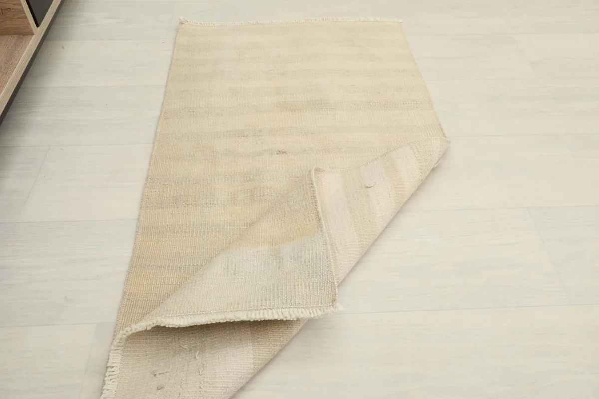 The rug partially folded, showing its flexibility and thickness.