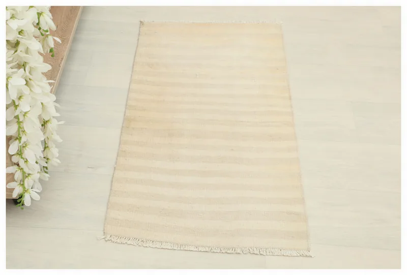 Full top view of the beige striped vintage Anatolian rug on a light floor