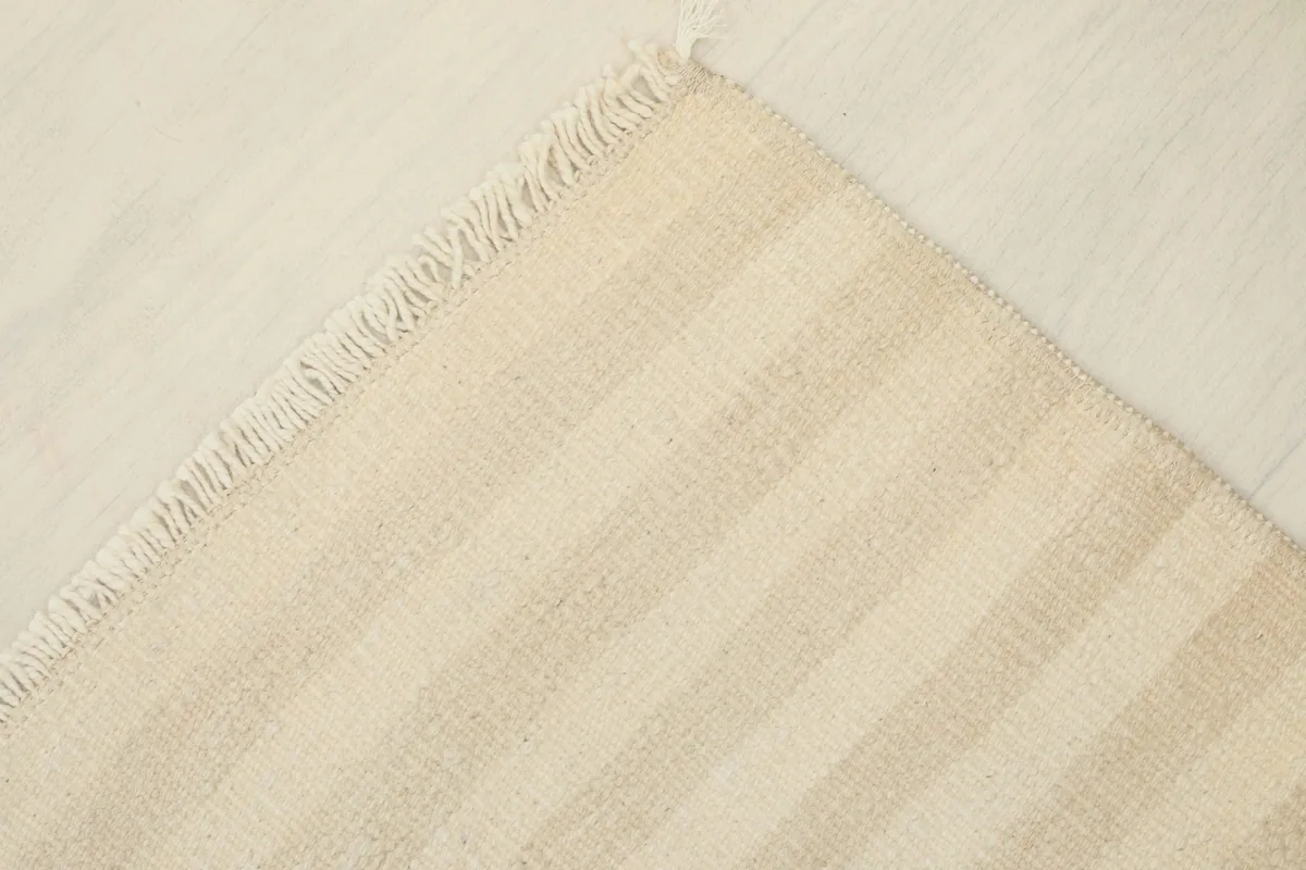 Underside view of a corner of the rug, revealing the cotton foundation