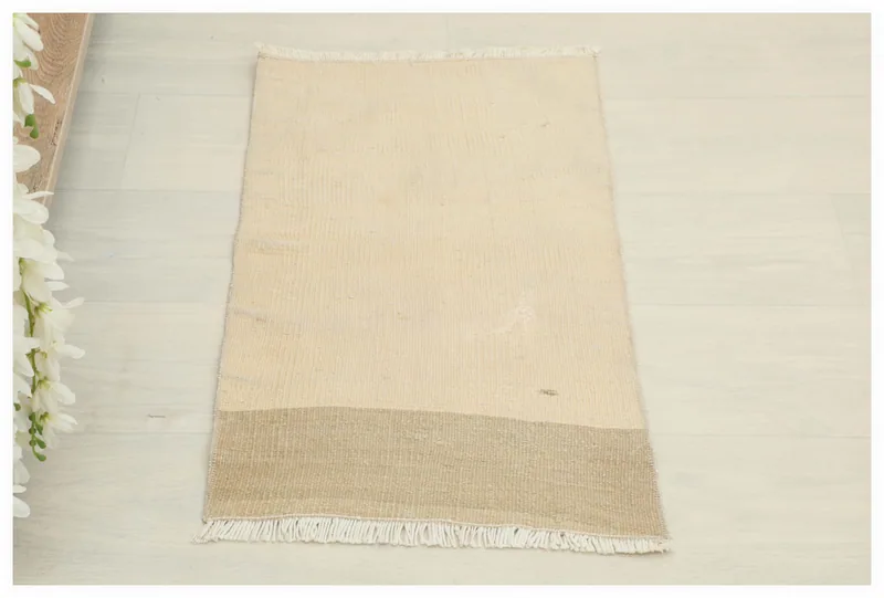 Full top view of the 1'4" x 2'2" ivory and tan vintage Anatolian rug on a white background.