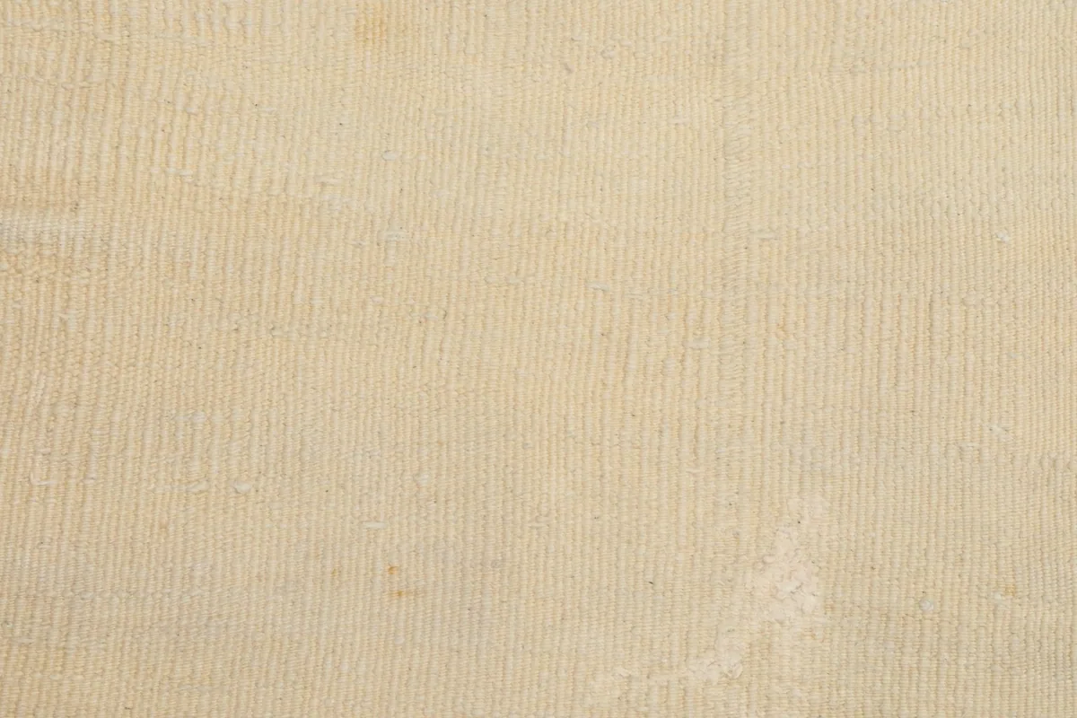 Close-up of the low wool pile, showing the tight knotting and soft texture of the vintage rug.