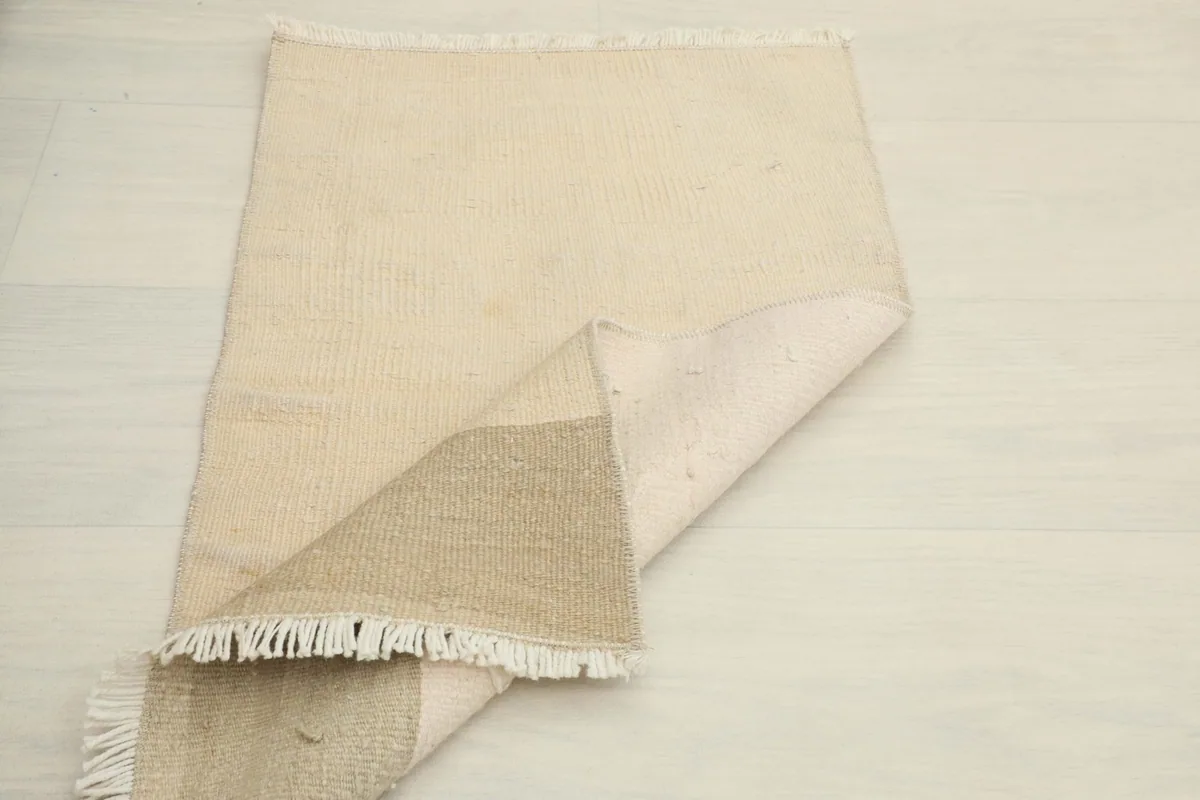 Overhead view with a corner folded, showing the back of the rug and the construction details.