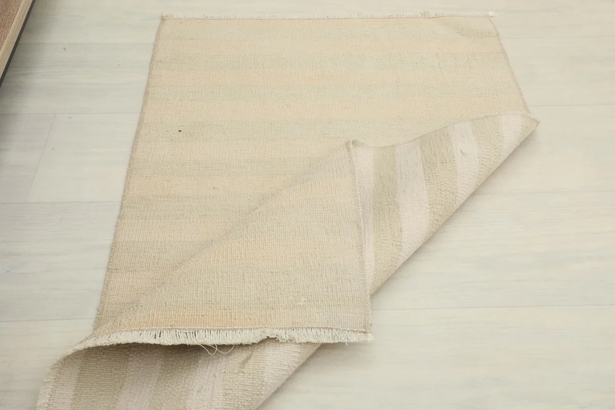 Partially folded rug on the floor, illustrating its size and construction.
